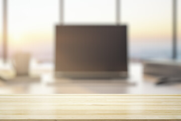 Empty wooden office table with light sunny workplace with computer on background, mockup