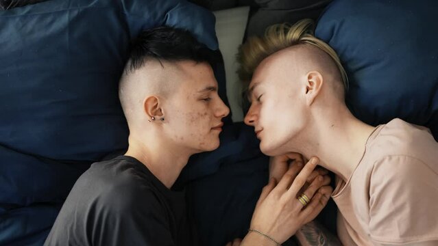 Gay couple in the bed together, sensually kiss