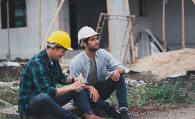 Engineering men are helping to plan the construction of the building.Engineer workers wear safety helmets.men at industrial work.