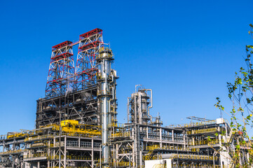 Fractionating column at an oil refinery. Production equipment at a petrochemical plant. Oil refining production. Production of chemical components and gasoline.