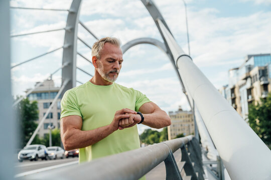 Mature man monitoring heart rate on smart watch