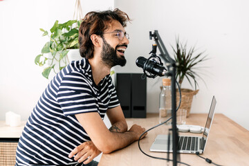 Happy content creator recording podcast in home studio
