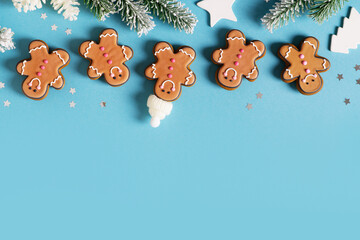 Row gingerbrads men on stick on blue background
