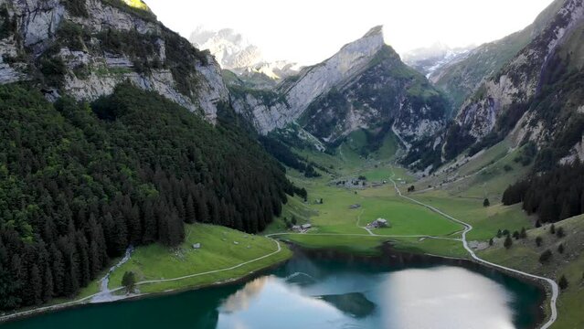 Aerial flyover over lake Seealpsee in Appenzell, Switzerland with a reflection of the Alpstein peaks on the lake's surface