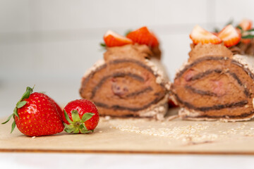 Rolled with fruits. Wonderful dessert. Homemade cake roll with chocolate and fresh strawberry. Chocolate swiss cake. Sweet roll cake. Chocolate strawberry roll cake. Sponge roll with blueberries