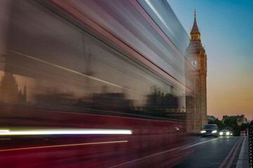 Fototapeta na wymiar Bus speeds past Big Ben at dawn