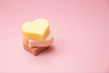 Heart shaped pink bar of soap on a light pink background. Top view, copy space. Heart shaped soaps. Importance of personal hygiene care. Copy space.