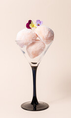 Japanese dessert or homemade ice cream in a glass decorated with live edible flowers.