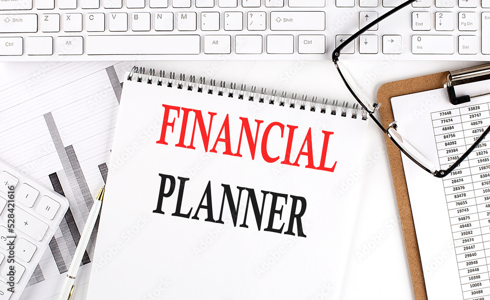 Poster text financial planner on office desk table with keyboard, notepad and analysis chart on white backg