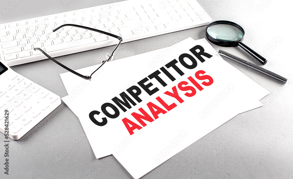 Poster competitor analysis text on a paper with keyboard, calculator on grey background