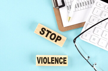 STOP VIOLENCE text written on wooden block with clipboard ,eye glasses and calculator Business...