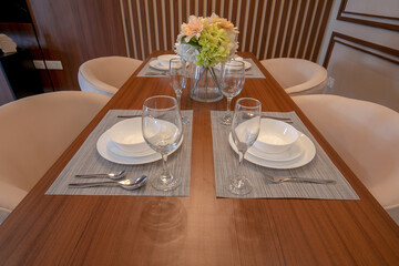 table set for dinner containing plates, glasses, spoons and forks