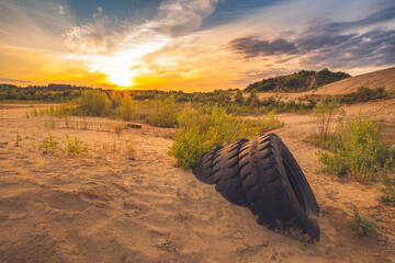 Colorful sunset over an abandoned sand pit with old tires