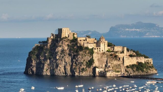 il Castello Aragonese di Ischia Ponte, Isola di Ischia. Italia.
Spettacolare ripresa con drone sullo sfondo di Capri.