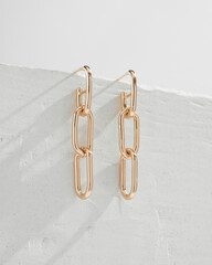 Set of golden chains shaped earrings isolated on white background.