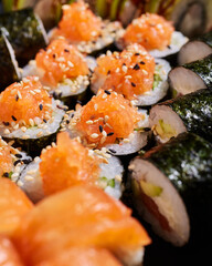 Close up of sliced maki rolls stuffed with fresh salmon, cucumbers and sesame seeds.