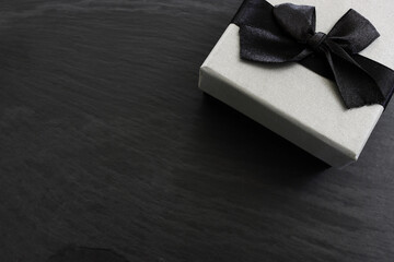Grey gift box on dark textured background. Top view