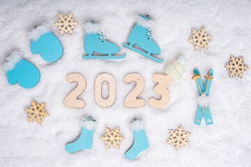 Sports year 2023. Sports set with bright blue wooden skates, skis, sledges, snowflakes and date...