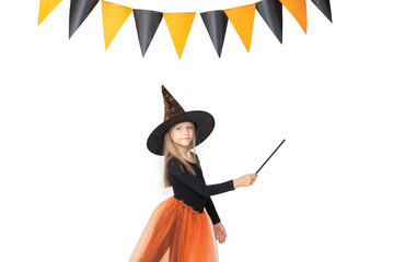 Kids Halloween. A beautiful cute girl in a witch costume, wearing a hat, holding a magic wand shows an empty space on a white background with a garland, copy space. The little sorceress.