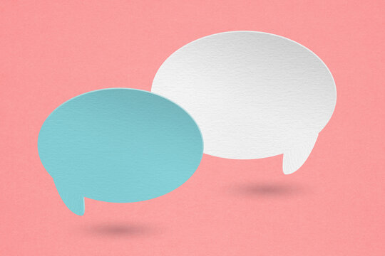 two blank speech bubble blue and white paper cut,  on grunge pink paper background. Conceptual image about communication and social media