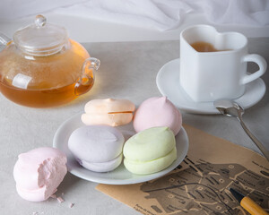 A bitten marshmallow, a cake, a flower, transparent glassware for a tea ceremony and a map on the...
