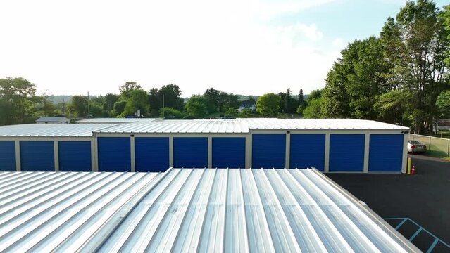 Aerial reveal of self-storage unit building. Warehouse temporary storage. Summer sunset.