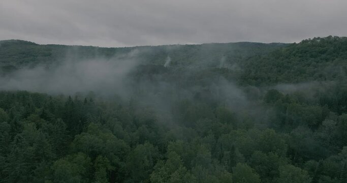 Drone flying through a beautiful foggy mountain top landscape, pullout reveal