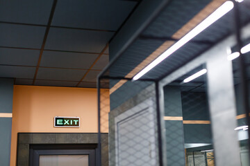 Exit sign in Ukrainian and English hangs above door in public place.