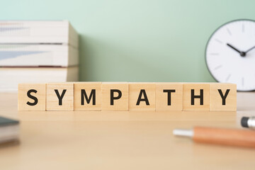 シンパシーのイメージ｜SYMPATHYと書かれたブロックが置かれたデスク
