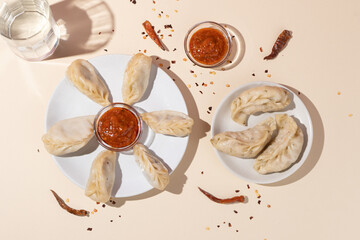 Fototapeta na wymiar Traditional Dumpling Momos Served on white plate with sauce.