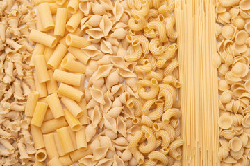 Uncooked pasta on white background. Food background. Top view.