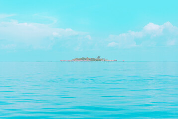 Fototapeta premium view from sea to island and water villas at day time with blue sky and beautiful clouds in the Maldives, the concept of luxury travel