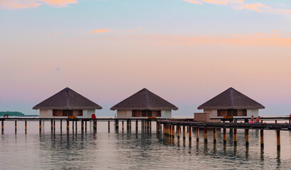 Fototapeta na wymiar view of the water villas at sunrise in the Maldives, the concept of luxury travel