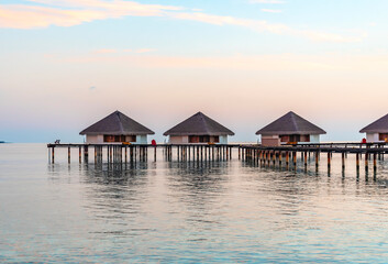 Obraz na płótnie Canvas view of the water villas at sunrise in the Maldives, the concept of luxury travel
