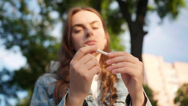 Woman crumples cigarette and quits smoking in park
