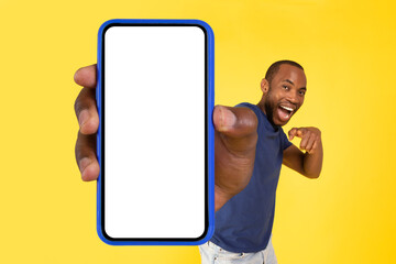 African American Male Showing Phone Blank Screen Over Yellow Background