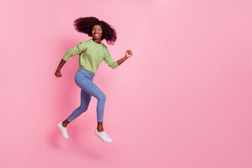 Fototapeta na wymiar Full length photo of sweet shiny girl dressed green pullover running fast jumping high empty space isolated pink color background
