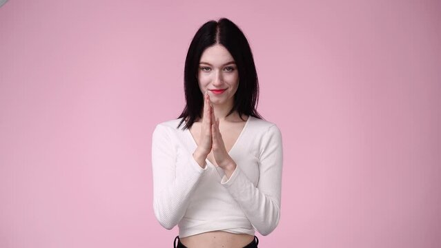 4k video of woman rubbing her hands together on pink background.