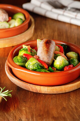 Fresh homemade sausages with broccoli and peppers made on the grill on the plate.