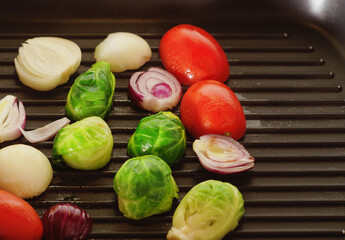Brussels sprouts with onion and tomato in a grill.