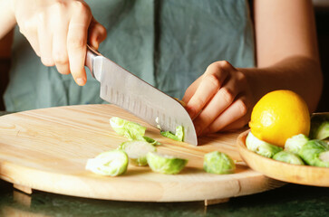 Woman cooking Brussel sprouts in kitchen.