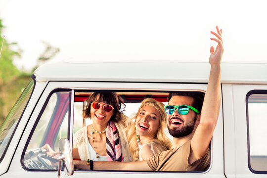 Photo of group cheerful overjoyed young people drive van raise hand through window enjoy weekend journey