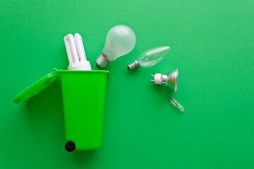 Stop energy waste concept: diverse old halogen and fluorescent light bulbs on their way into a...