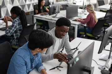 Male high school students studying a drone in class