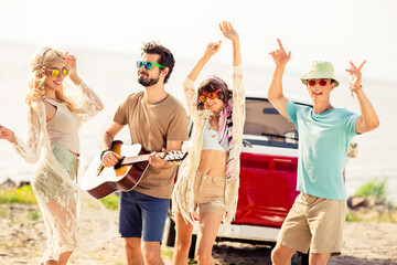 Photo of group overjoyed positive people dancing have fun play acoustic guitar free time outdoors