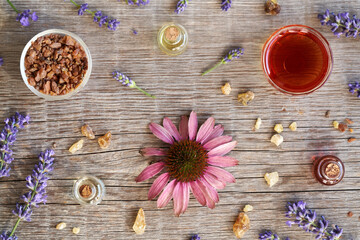 Backgrond with essential oil bottles with frankincense resin, echinacea and lavender flowers, top view