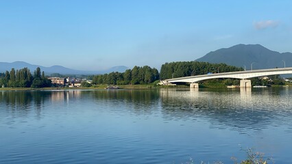 Fototapeta premium The lakeside scenery with after 6am sunrise light, the beautiful morning in the countryside of Japan, Kawaguchiko, Yamanashi year 2022 August 27th