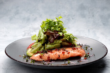 Salmon fillet with vegetables and salad leaves