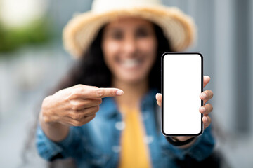 Woman in straw hat pointing at cell phone empty screen