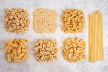 Uncooked pasta on white background. Food background. Top view.